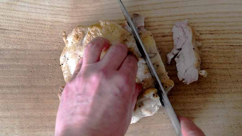 鶏肉を取り出して食べやすい大きさに切っている写真です。