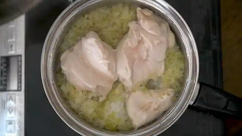 完成した「海南チキンライス釜めし」の写真です。蒸らされた鶏肉が白色に変わっています。