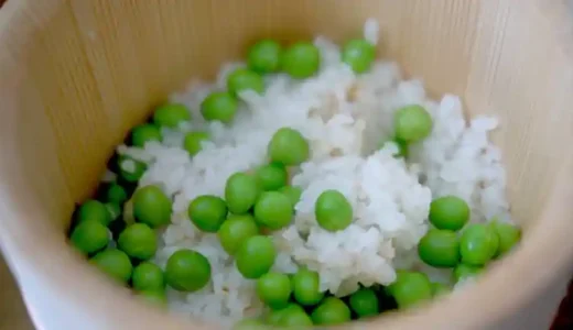 おひつに入った豆ご飯の写真です。豆は鮮やかな緑色で、表面にはシワがよっていません。