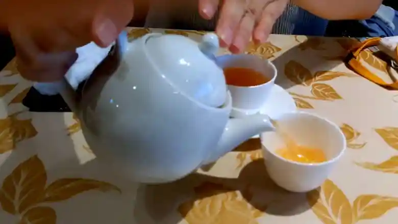 お茶の入ったポットの写真です。ポットは薄い水色です。