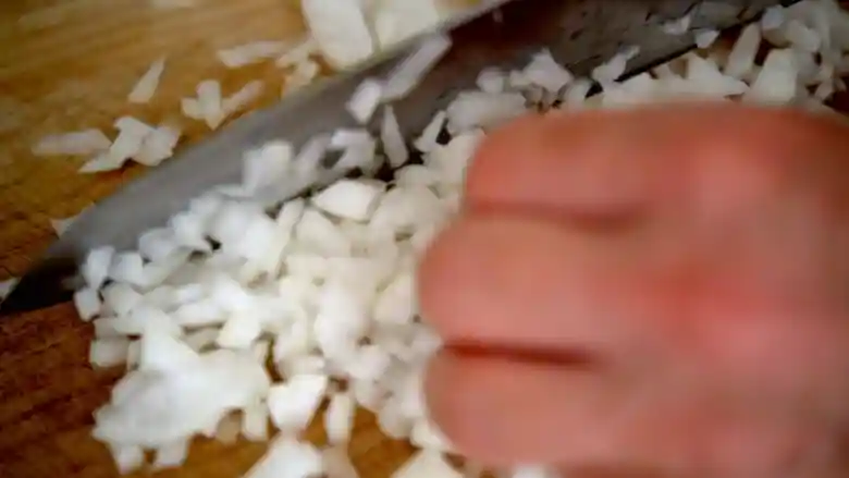玉ねぎを包丁でみじん切りにしている写真です。