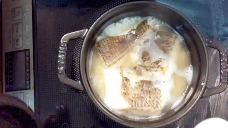 米と焼いた鯛をいれた鍋がブクブクと沸騰している写真です。