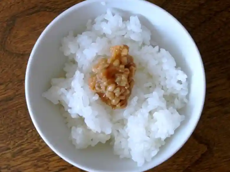 ご飯に「しょんしょん」をよそったの写真です。「しょんしょん」は大豆と大麦で作った麹を醤油で仕込んだなめ味噌です。
