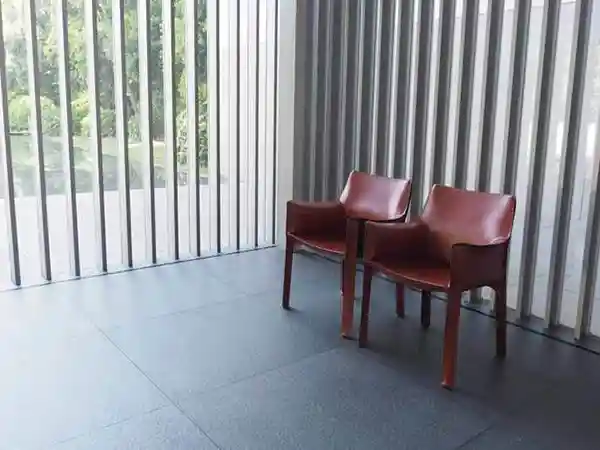 This photo displays a group of wine-colored, leather-upholstered armchairs in the entrance hall on the first floor of the Gallery of Horyuji Treasures. These armchairs were designed by Italian designer Mario Bellini (1935- ). 