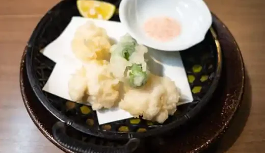 真鱈の白子天ぷらの写真です。すだちとししとうが添えられています。梅塩をつけて食べます。