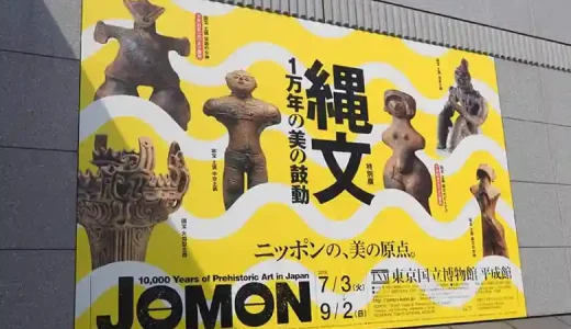 特別展「縄文－1万年の美の鼓動」の看板の写真です。東京国立博物館の平成館の入り口に設置されています。高さは3m、幅が4mほどの大きな看板です。背景は黄色で、国宝に指定されている土偶5体と火焔型土器1点が並んでいます。