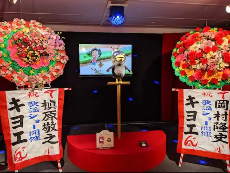 4月に『大好きって意味だよ』で歌手デビューしたキョエちゃんのステージの写真です右側に槇原敬之から、左側に岡村隆史さんから贈られた花輪が飾られています。