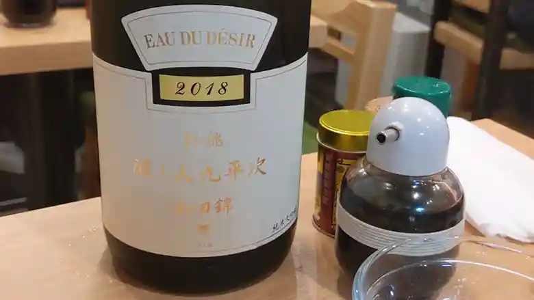 愛知県の萬乗酒造の醸し人九平次 純米大吟醸 別誂のボトルの写真です。黒いビンに白いラベル、金色の文字。使用品種は山田錦。熟した果実の香りとほのかな甘味をもつお酒です。