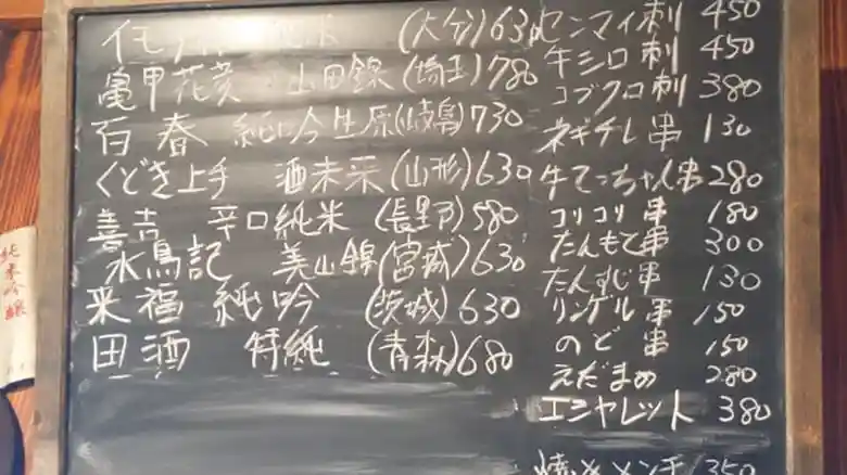 黒板に描かれたメニューの写真です。黒い黒板に白墨で、おすすめの日本酒と食事が書かれています。