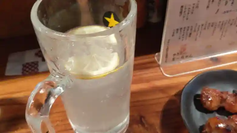 シャリキンレモンサワーの写真です。冷えたグラスの中にシャーベットになったキンミヤが入っています。レモンを入れて炭酸で割って飲みます。