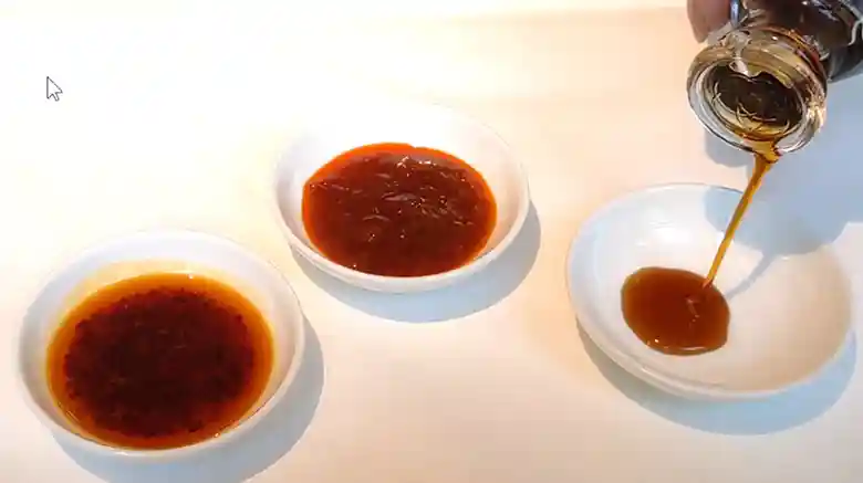 ソースは3種類用意されています。左からチリオイル、味噌ベースのチリソース、醤油とごま油が白い皿に入って並んでいます。
