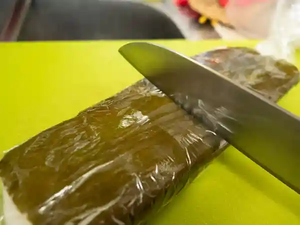 鯖寿司を包丁で切り分けている写真です。