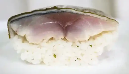 さば寿司の断面の写真です。表層から昆布、千枚漬け、しめ鯖、すし飯が層になっています。しめ鯖は肉厚で厚さは2cmです。