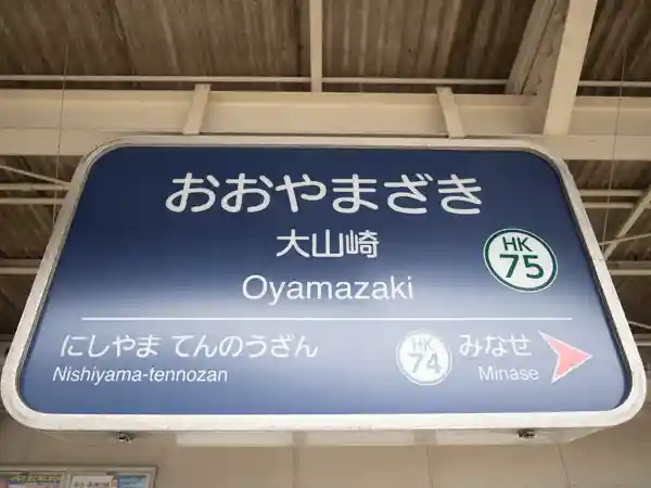 京阪急京都本線の大山崎駅の駅名標の写真です。青い金属製の板に白色の文字で上から「おおやまざき、大山崎、Oyamazaki」と印刷されています。前の駅は「にしやま てんのうざん」、次の駅は「みなせ」と白色の文字で印刷されています。