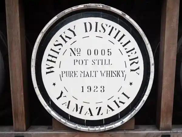 サントリー山崎蒸留所のウイスキー館の写真の入り口脇に積み重ねられたウイスキー樽の写真です。「NO.0005 PURE MALT WHISKY 1923」と刻印が押されています。