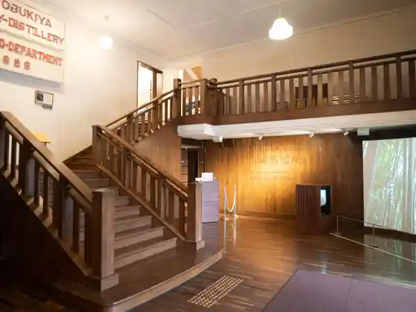 サントリー山崎蒸留所のウイスキー館のエントランスの写真です。木製の階段が写っています。