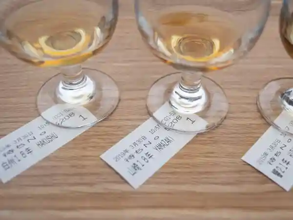 サントリー山崎蒸留所ウイスキー館内に設けられたテイスティングカウンターで注文したウイスキーの写真です。長期熟成ウイスキー体感セットを注文しました。3つのグラスにウイスキーが注がれています。左から「白州18年」「山崎18年」「響21年」です。