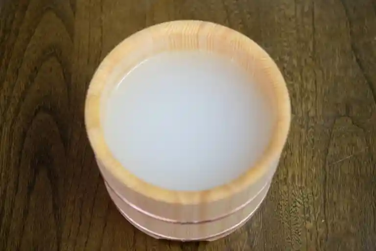 米の研ぎ汁をお櫃に満たした写真です。米の研ぎ汁は白く濁っています。
