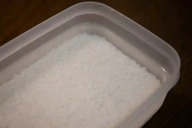 浸漬米の写真です。タッパーに入った水の中に米が浸してあります。タッパーの蓋をして冷蔵庫に保存します。
