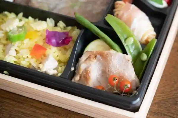 「BISTRO J_O 厳選欲張り重」の容器の右下方の写真です。「エビポテトと生ハム」と「塩麹味噌豚と焼き野菜夏野菜」が写っています。