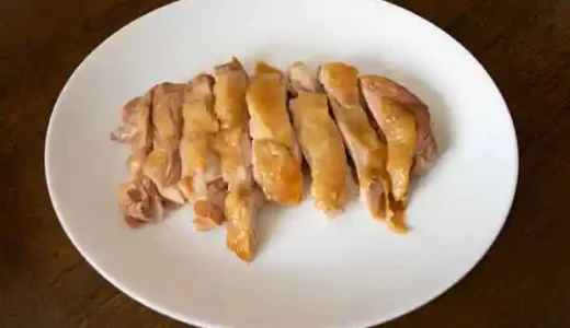 切り分けた鶏もも肉を白い皿にもった写真です。もも肉は1cm幅に切り分けられています。もも肉の皮は薄い茶色でパリパリに焼けています。