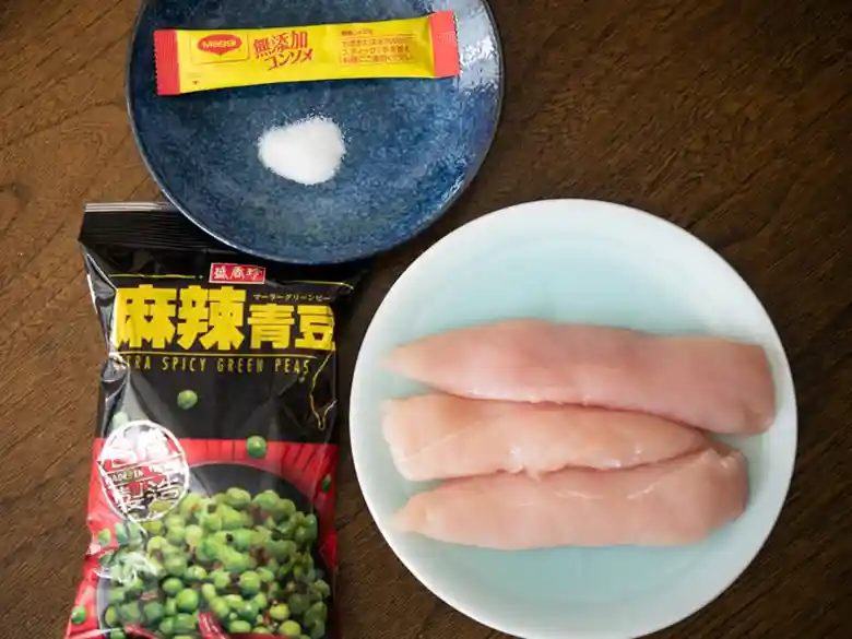 スパイシ～青豆☆釜飯の材料の写真です。袋に入った麻辣青豆、コンソメと塩、更にもられた鶏のささみ肉が写っています。
