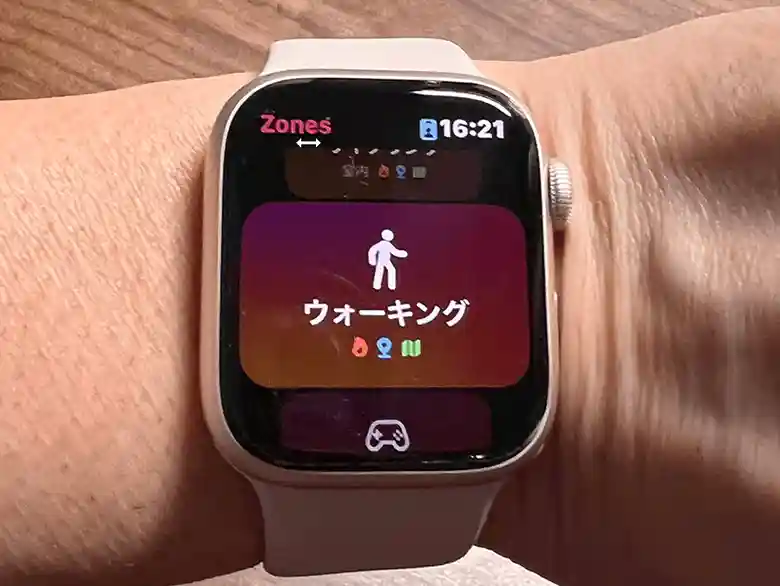 インターバル速歩を開始する前に撮影したApple Watchの画面の写真です。Zonesという心拍トレーニングアプリを開いています。画面には歩行中の人のピクトグラムが描かれ、その下にウォーキングと記されています。この画面をタップだけでウォーキングの運動データを測定できます。