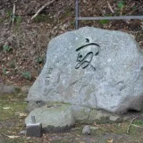 谷崎潤一郎夫妻の墓石の写真です。谷崎潤一郎の直筆による寂という字が彫られています。薄い灰色の鞍馬石の墓石で高さ1m、幅2m程の大きさです。