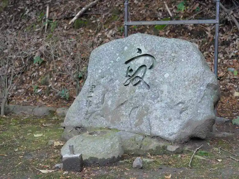谷崎潤一郎夫妻の墓石の写真です。谷崎潤一郎の直筆による寂という字が彫られています。薄い灰色の鞍馬石で、高さ1m、幅2m程の大きさです。