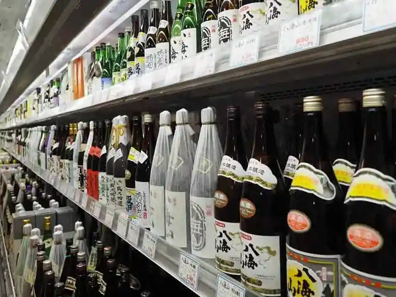 吉池ビル地下2階の酒売り場の様子です。壁一面に日本酒の一升瓶が並んでいます。
