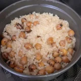 ご飯が炊けたのでストウブ鍋の蓋をとった写真です。ご飯はたまり醤油で薄い茶色に染まっています。ご飯と豆はつやつや輝いています。