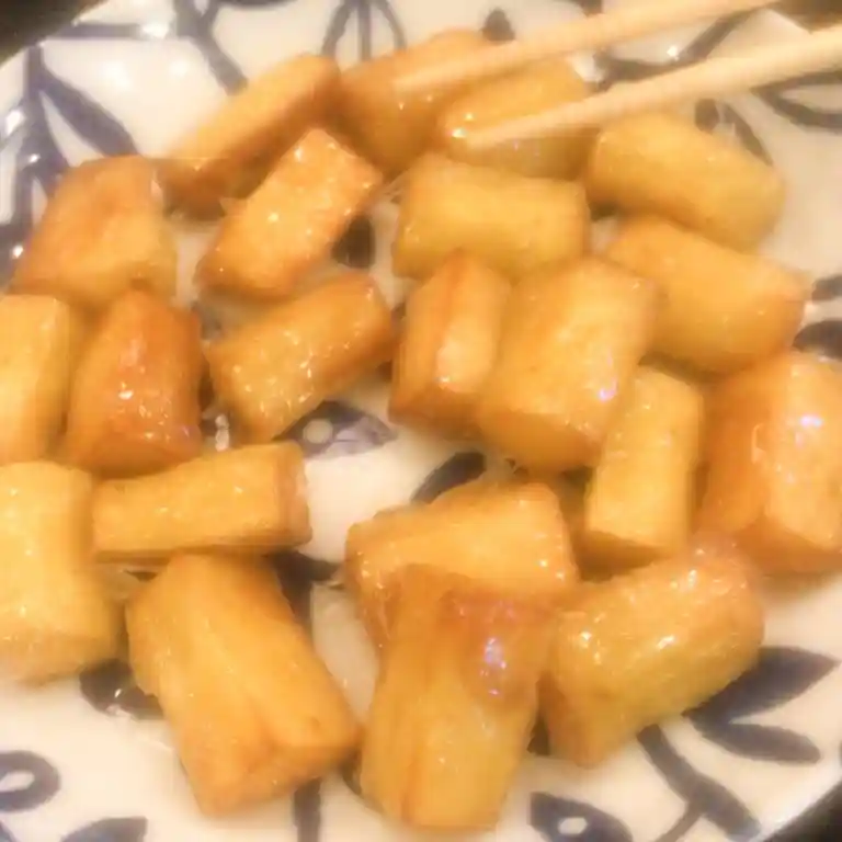This photo shows Chinese-style candied sweet potatoes. Crispy fried sweet potatoes are covered with molasses, made by boiling sugar and water.