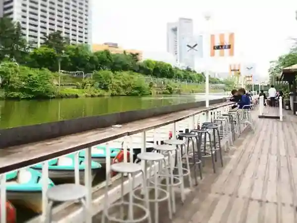 This photo shows the view of the moat from the Boat Deck of the Canal Cafe. The tables are arranged to face the moat, and boats can be seen floating on the water in front of the tables.