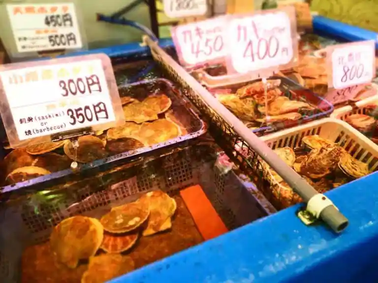 三角市場の写真です。、ホタテ貝と牡蛎が並べられています。