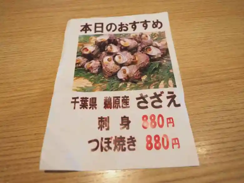 さざえの写真が印刷されたメニューの写真です。千葉県鵜原のさざえです。刺身が880円、つぼ焼きが880円と印刷されています。