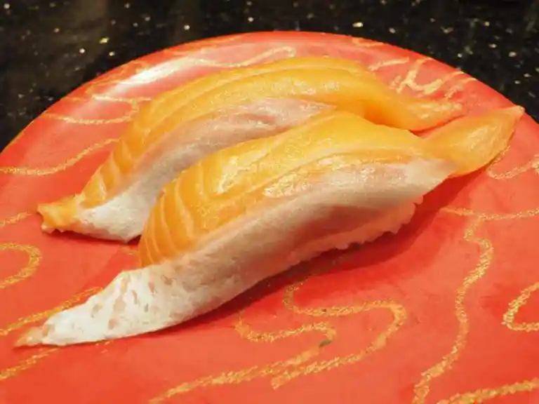 生サーモンの握りの写真です。脂がのって、鮮やかなオレンジ色をしています。