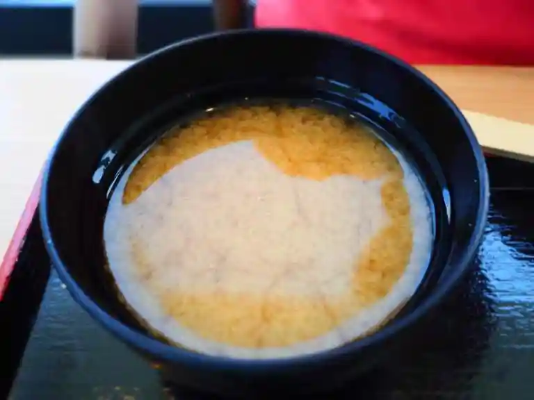 秋刀魚定食についてきた味噌汁の写真です。器は黒色をしています。具材はしじみでした。