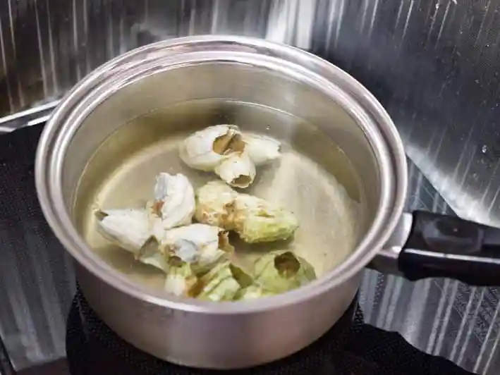 ミネフジツボを茹でている写真です。鍋にミネフジツボが浸る量の水を入れ、塩と日本酒を加えて湧かしています。