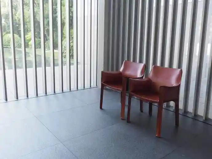 法隆寺宝物館1階のエントラスホールに備えられた椅子の写真です。2脚のワイン色で革張りのアームチェアが並んでいます。アームチェアはイタリアのマリオ・ベリーニ（Mario Bellini,1935- ）がデザインしました。