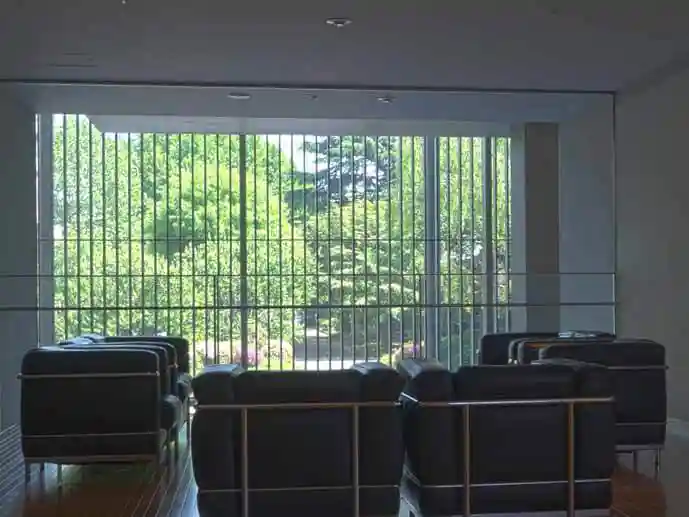 法隆寺宝物館の資料室に備えられたソファの写真です。目の前の窓から庭の木々が綺麗に見えています。