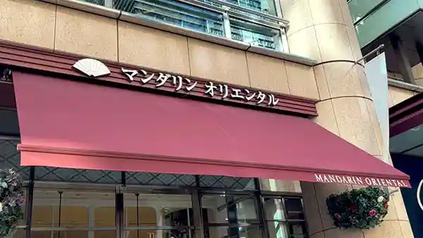 マンダリンオリエンタル東京の入り口の写真です。看板には扇のロゴマークと「MANDARIN ORIENTAL TOKYO」という文字が描かれています。