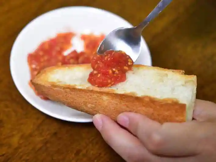 トマトの果肉をパンにのせている写真です。