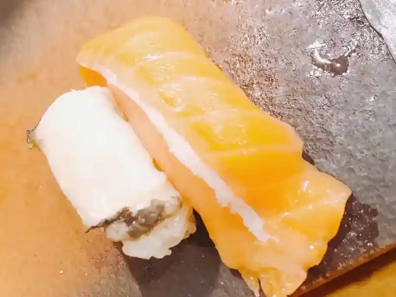 お寿司の写真です。白いのはアワビ、オレンジリオの握りはサーモンです。