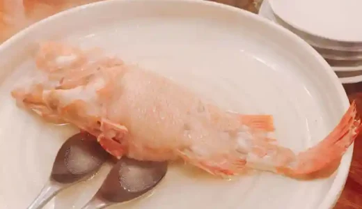 めんめの酒煮の写真です。他の地域ではキンキと呼ばれる魚です。鯛のような赤い色をした魚が白い魚の上に置かれています。