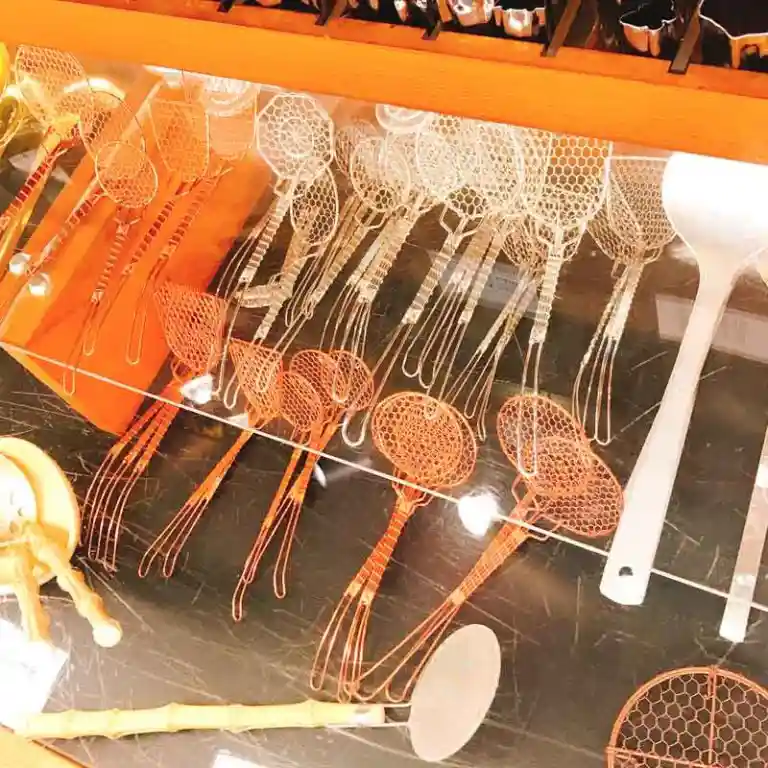 This picture shows the show window of Aritsugu. There are various sizes of ladles made of woven aluminum wire. These ladles are used to scoop tofu.