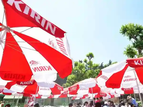 This photo shows the a la carte section of Forest Beer Garden. The tables are equipped with colorful parasols, which are red and white. The parasols stand out and add to the lively atmosphere of the garden.