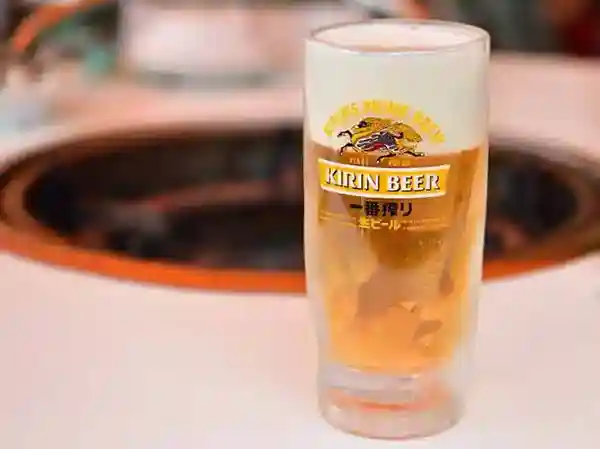 This image depicts a glass filled with a beer called KIRIN Ichiban Shibori. The surface of the glass displays a depiction of the Kirin, a legendary animal from ancient China.