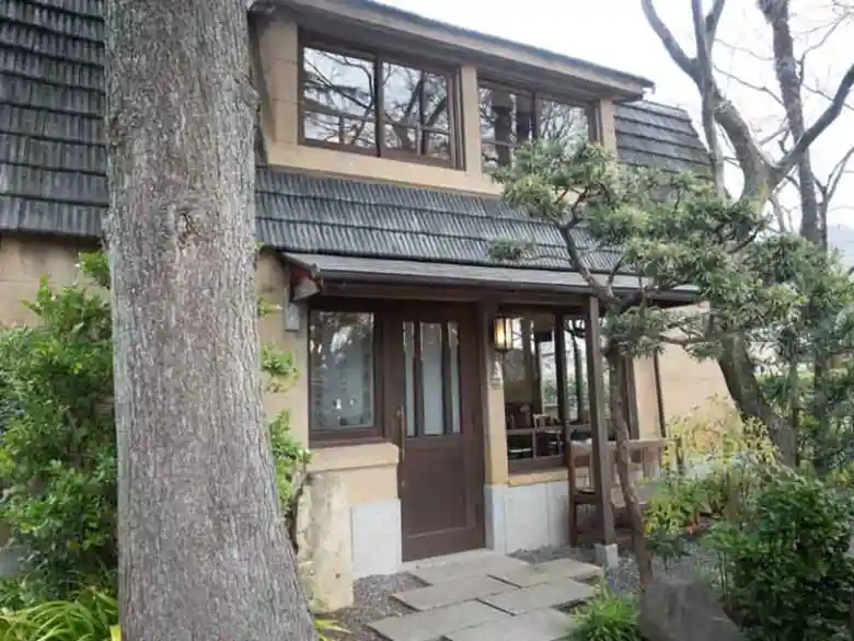 This photo shows Café Shinkokan. It is located at the top of the hill. The house looks like a mountain hut.