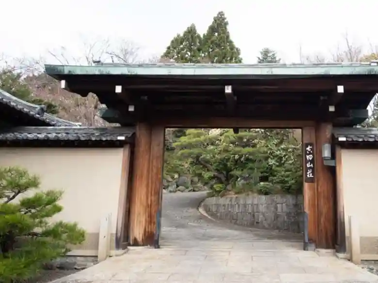 This photo shows the Karamon gate at the entrance of Yoshida Sanso. The gate has an imposing structure. Nishioka Tsunekazu, a master carpenter and a person of cultural merit, built this gate. 
