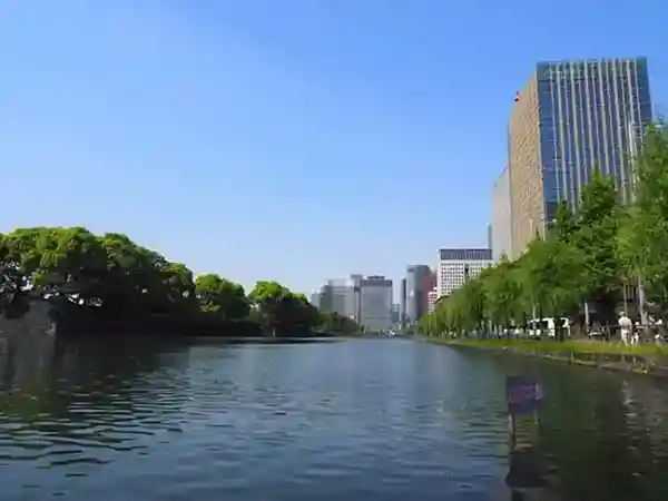 This photograph shows the moat of the Imperial Palace as seen from Yurakumon Gate in Hibiya Park. The Imperial Palace is located on the left side of the moat, while tall buildings can be seen on the right side.